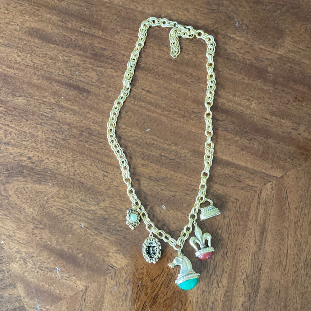 Gold tone charm necklace. Adjustable length. Great condition.